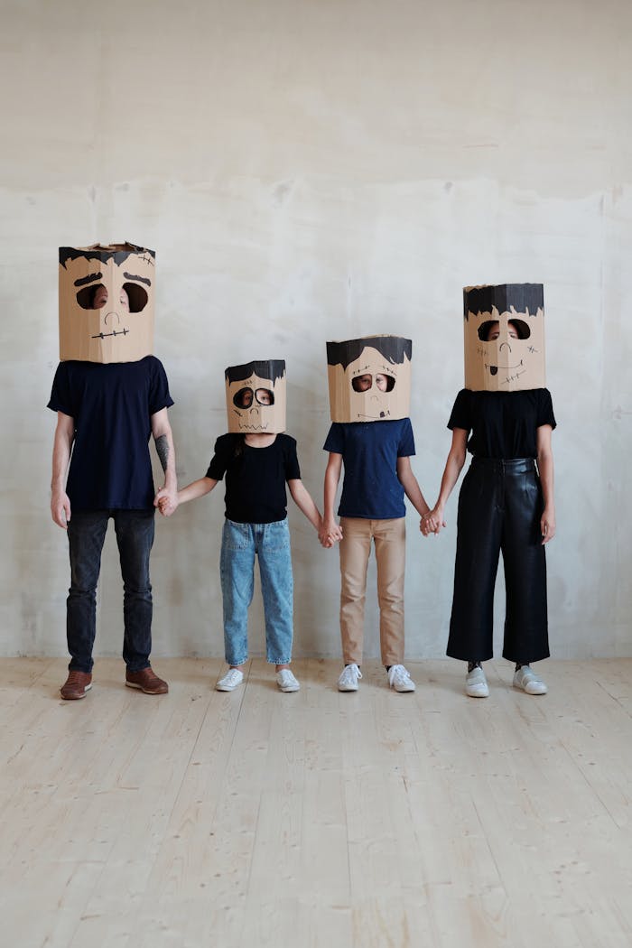 Mastering the First Impression: Your intriguing post title goes here Family dressed in DIY cardboard costumes, holding hands for Halloween fun.